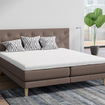 Boxspringbett Philrouge EOS Slim inszeniert in braun mit Holzfüssen und Dekokissen