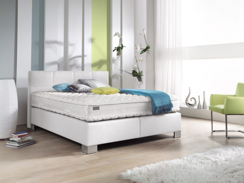 Boxspringbett Philrouge EOS inszeniert in weiss mit Chrome Füssen und Dekokissen