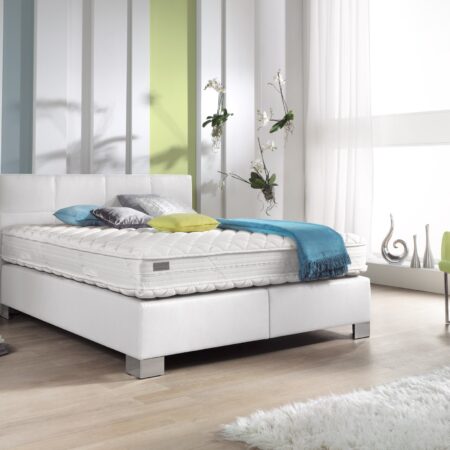 Boxspringbett Philrouge EOS inszeniert in weiss mit Chrome Füssen und Dekokissen