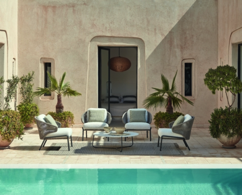 Manutti Radius Lounge Sessel mit Beistelltisch vor einem Pool